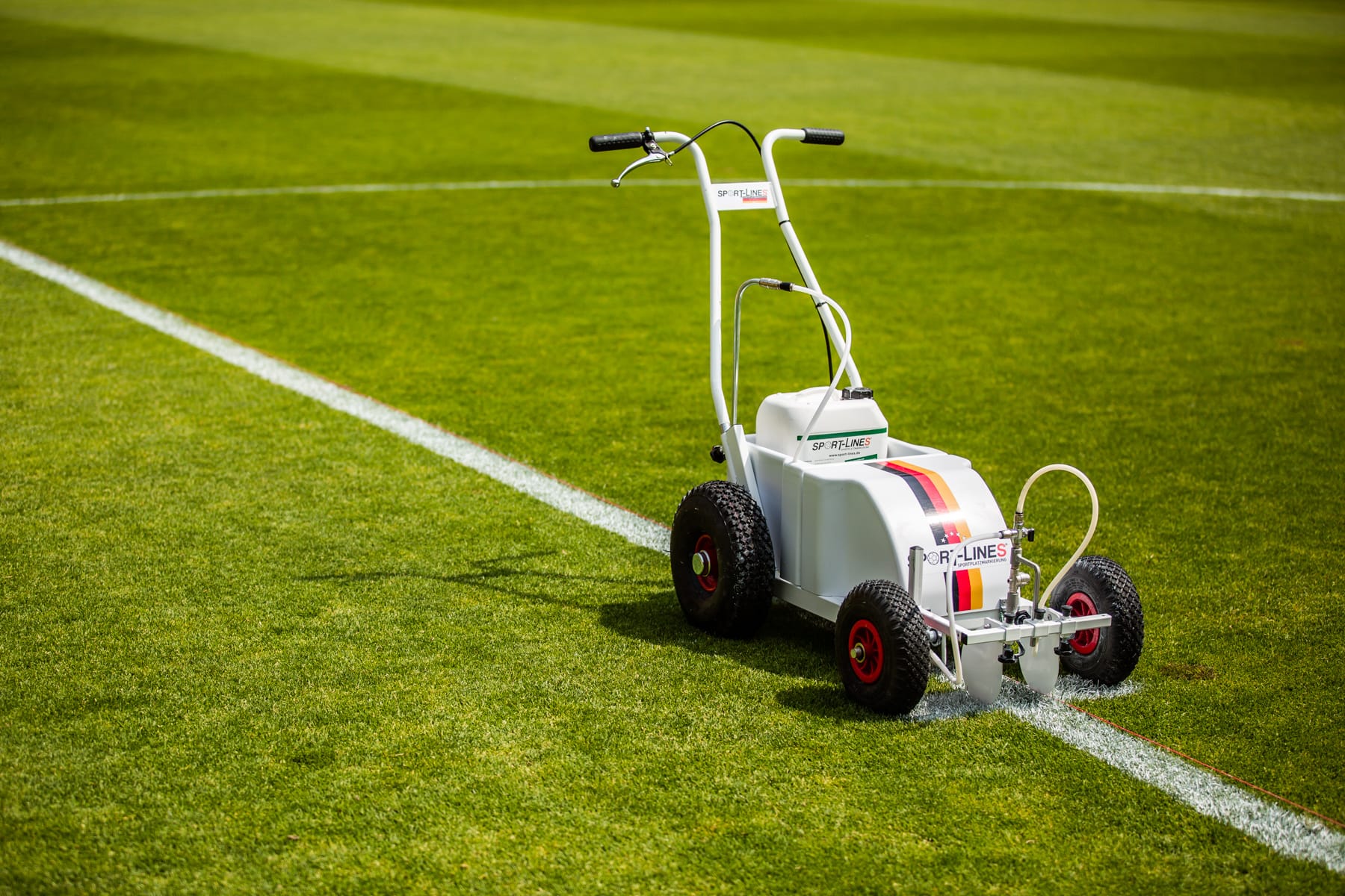 Sport-Lines Markiergerät zieht eine weiße Linie auf Naturrasen